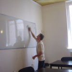 student writing on a whiteboard during a class